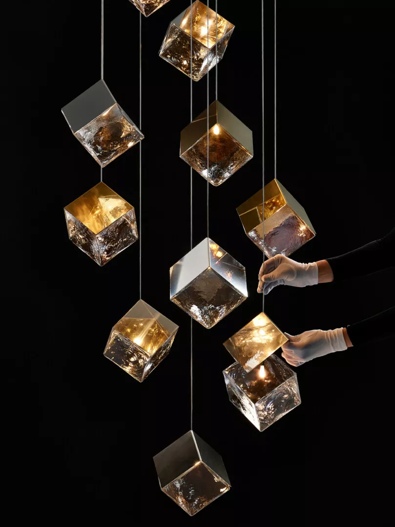 Elegant glass cube chandeliers with glowing golden lights.