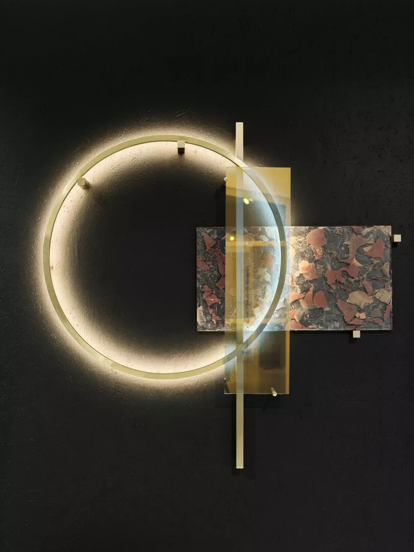 Modern circular wall lamp with terrazzo accent.