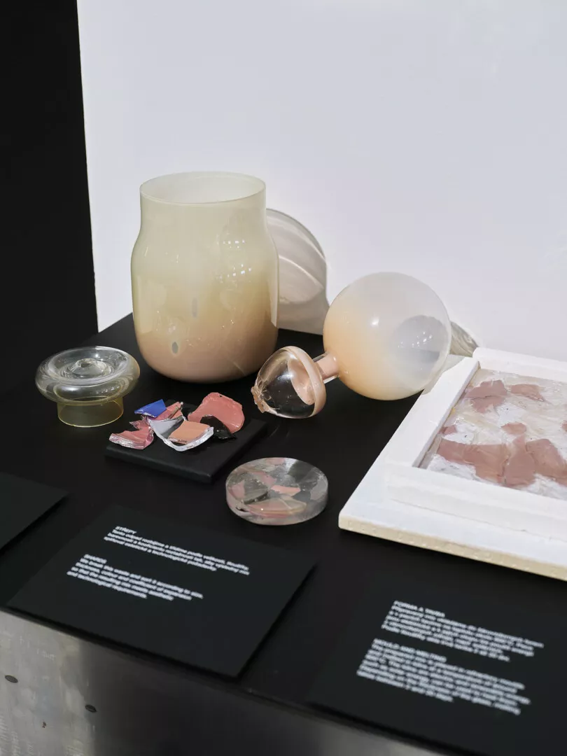 Assorted glass objects and fragments on display table.