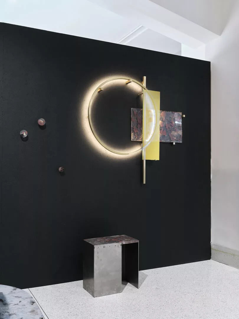Modern art installation with circular light and abstract elements.
