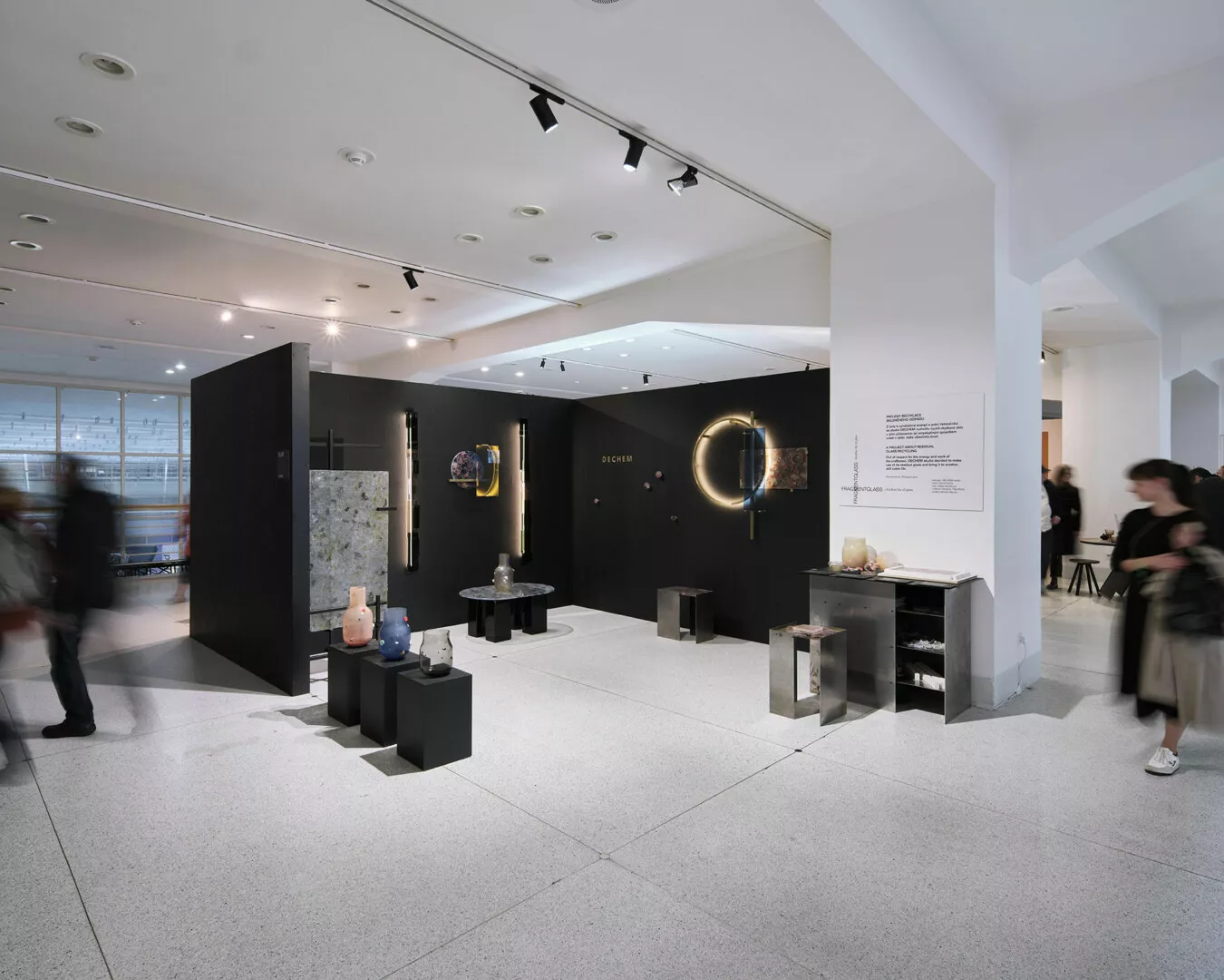 Modern art exhibition space with visitors and sculptures.