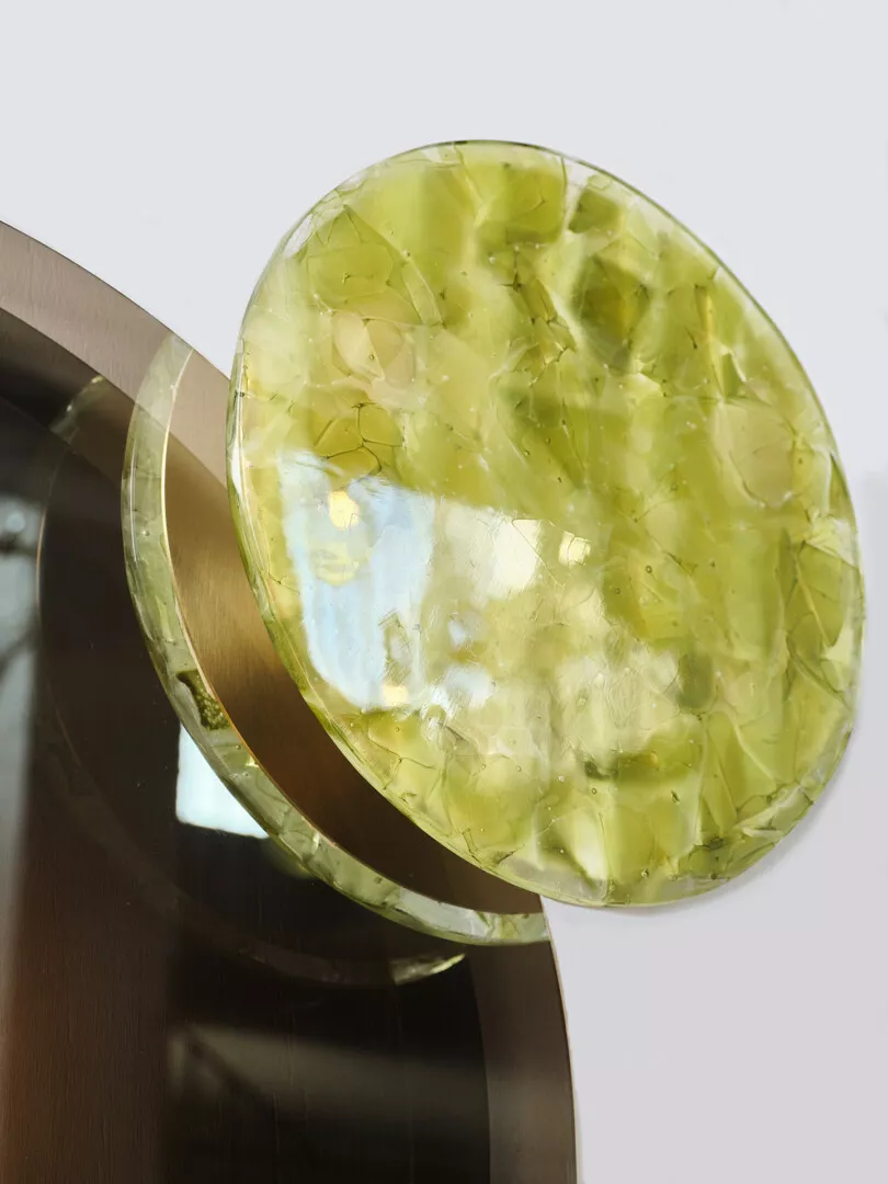 Close-up of translucent green gemstone on metal stand.