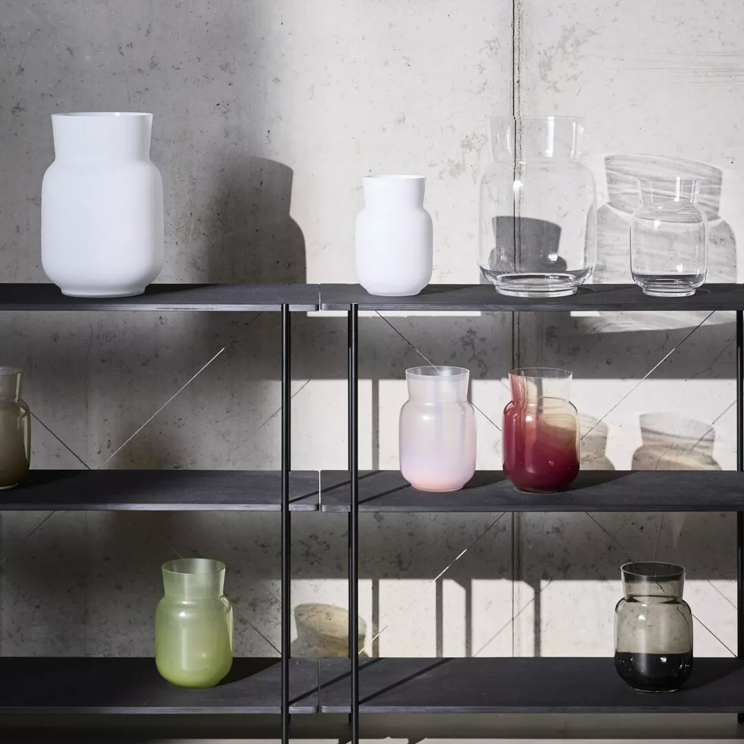 Assorted glass vases on modern metal shelving unit.