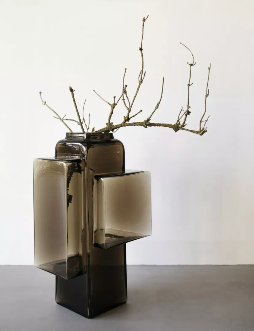 Modern ceramic sculpture with abstract branches on white background.