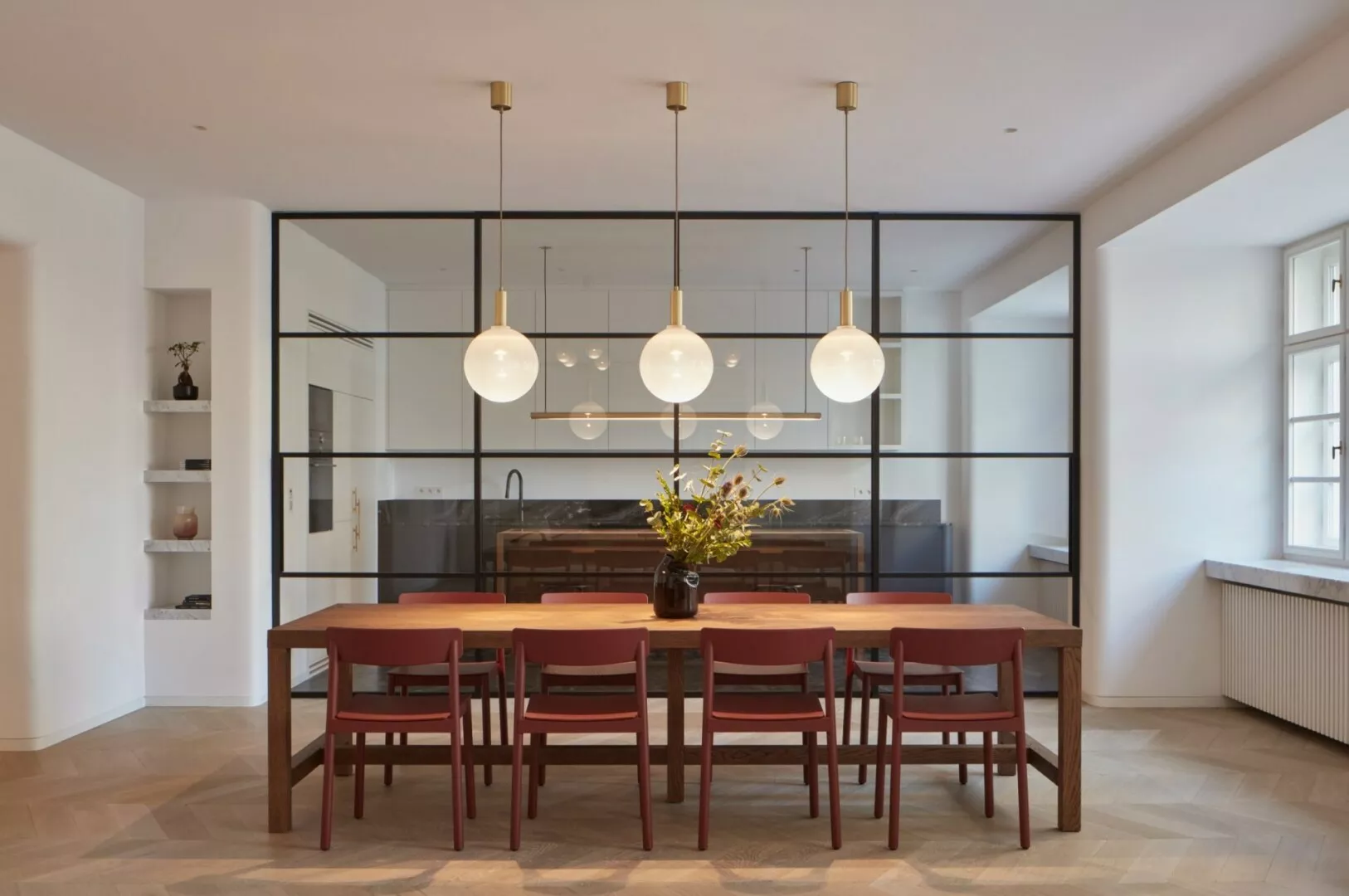 Modern dining room with glass partitions and pendant lights.