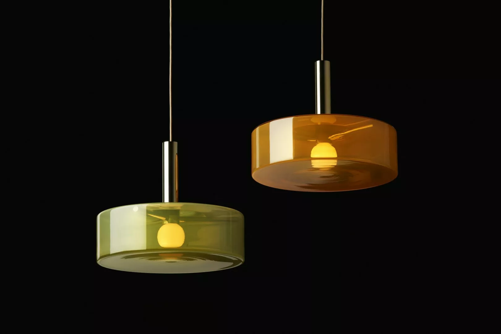 Two hanging lamps with amber and green glass shades.