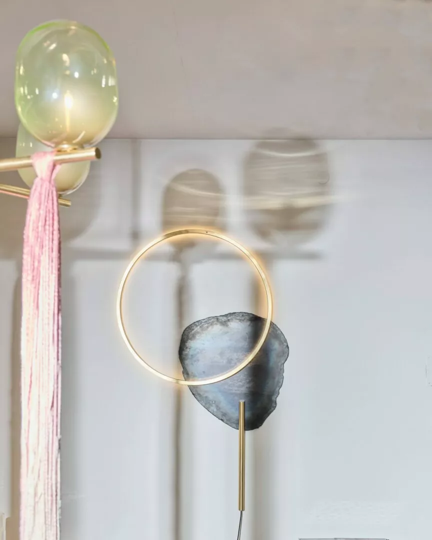 Modern wall lamp with circular design and stone accent.