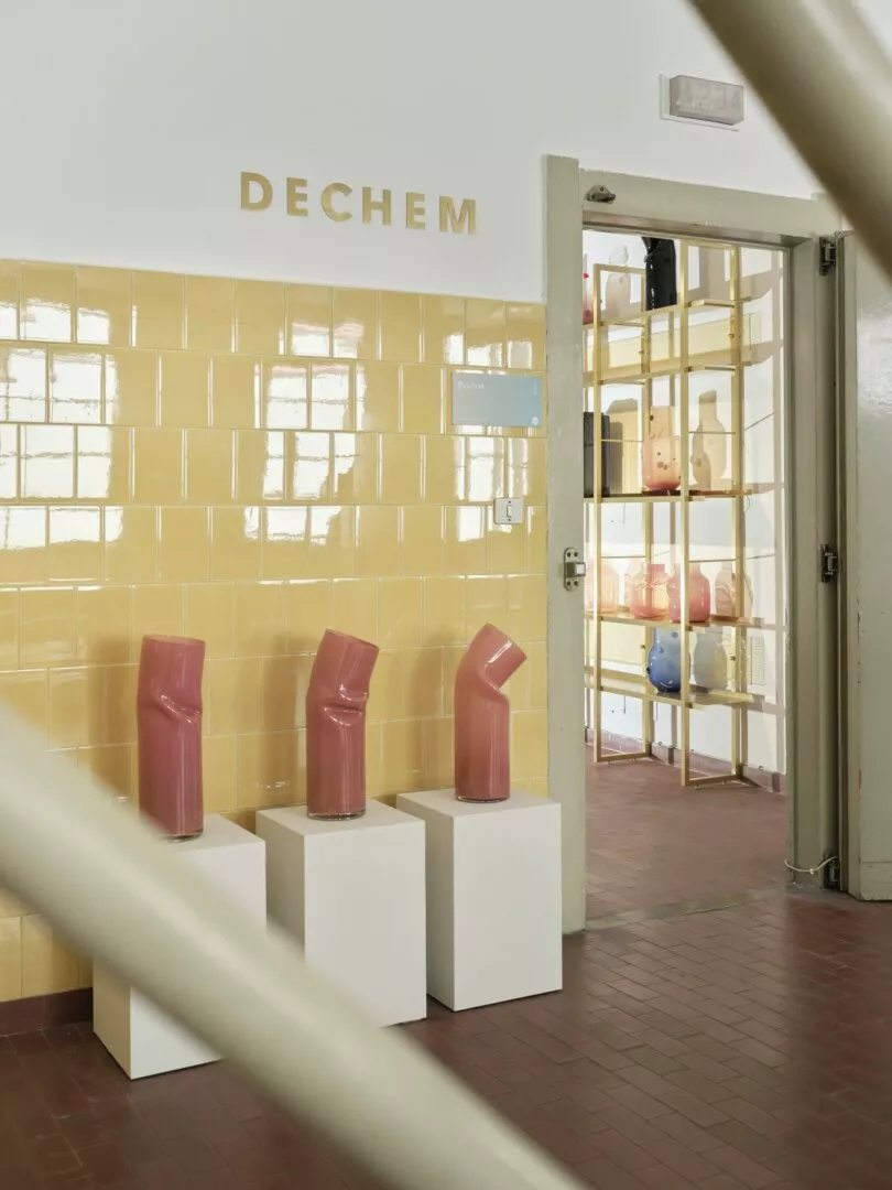 Modern sculptures on display in bright, tiled DECHEM studio.