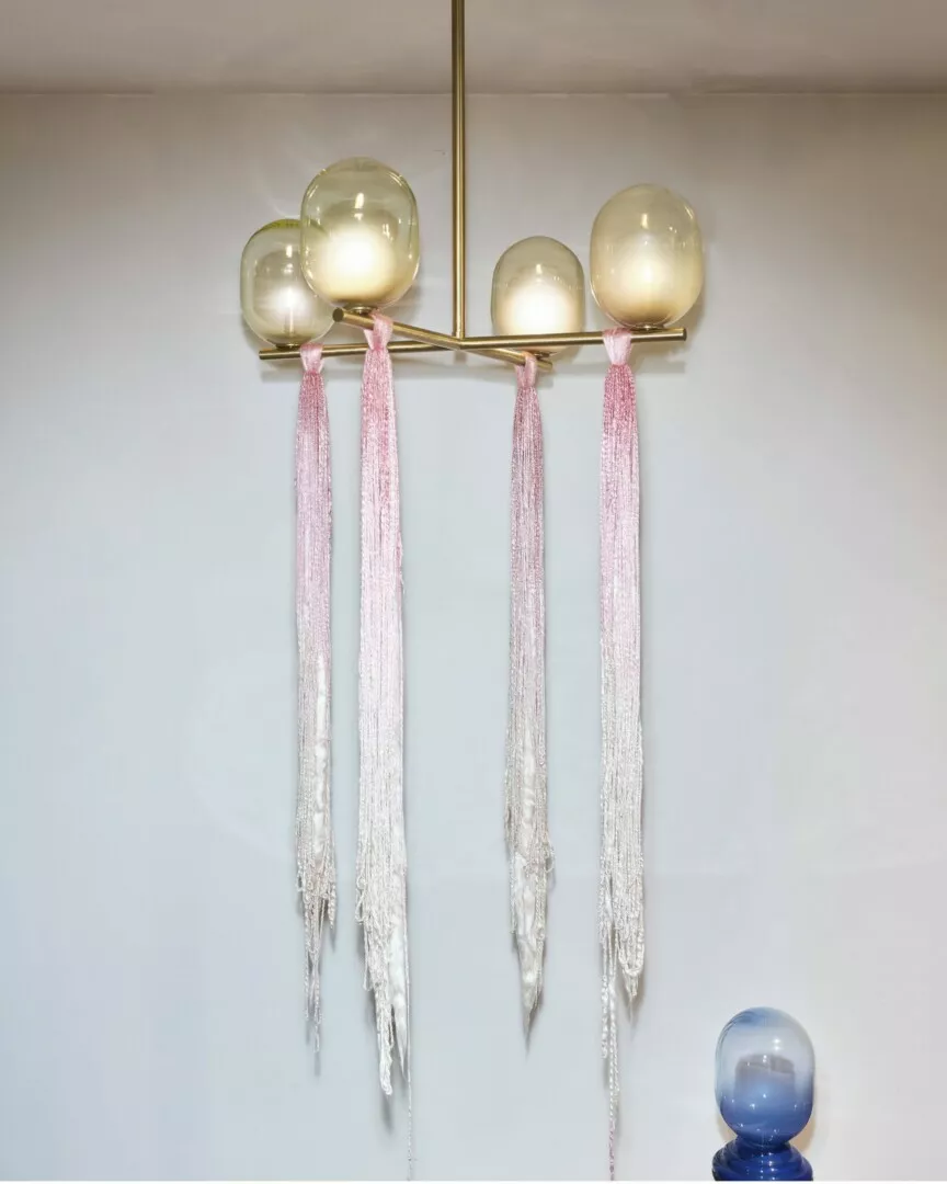 Elegant chandelier with pink tassels and glass orbs.